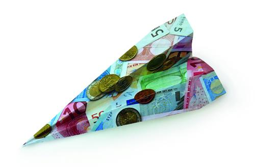 Papier met afgedrukt geld gevouwd in een vliegtuigje