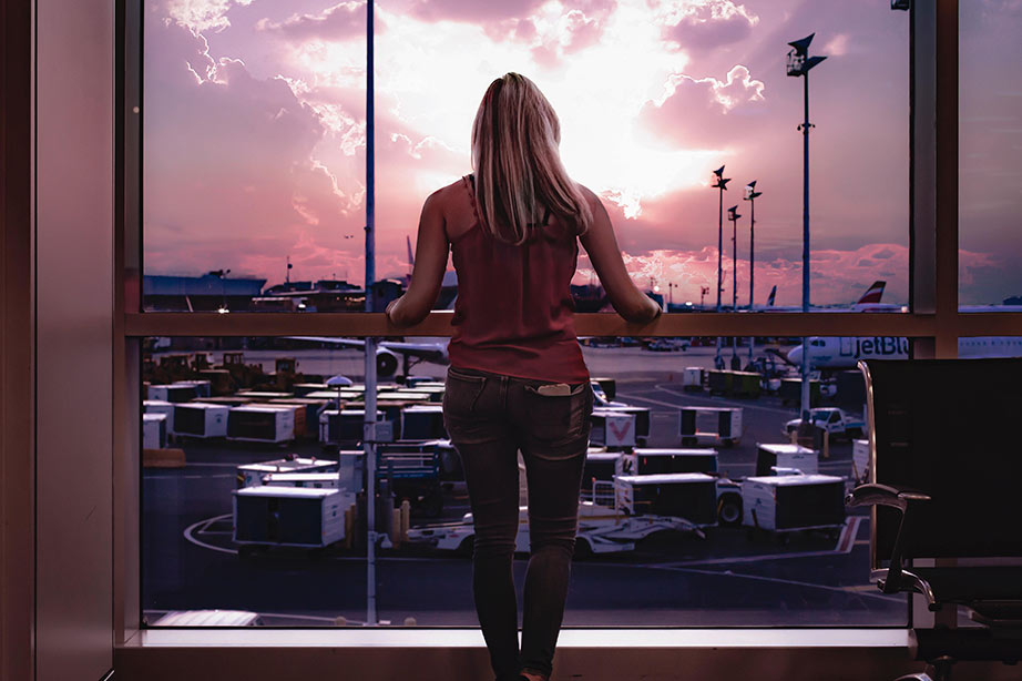 passagier wacht op luchthaven en kijkt naar zonsondergang