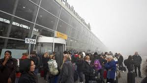 Wachtende passagiers op Eindhoven Airport in de mist