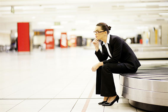 vrouw wacht op bagage op bagageband