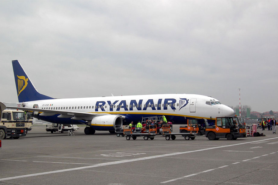 bewolkte lucht ryanair vliegtuig geparkeerd terwijl bagage wordt uitgeladen