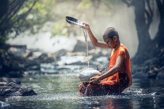 thailand monnik die water ritueel uitvoert in rivier