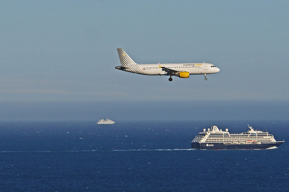 landend vliegtuig boven cruiseschip en de zee