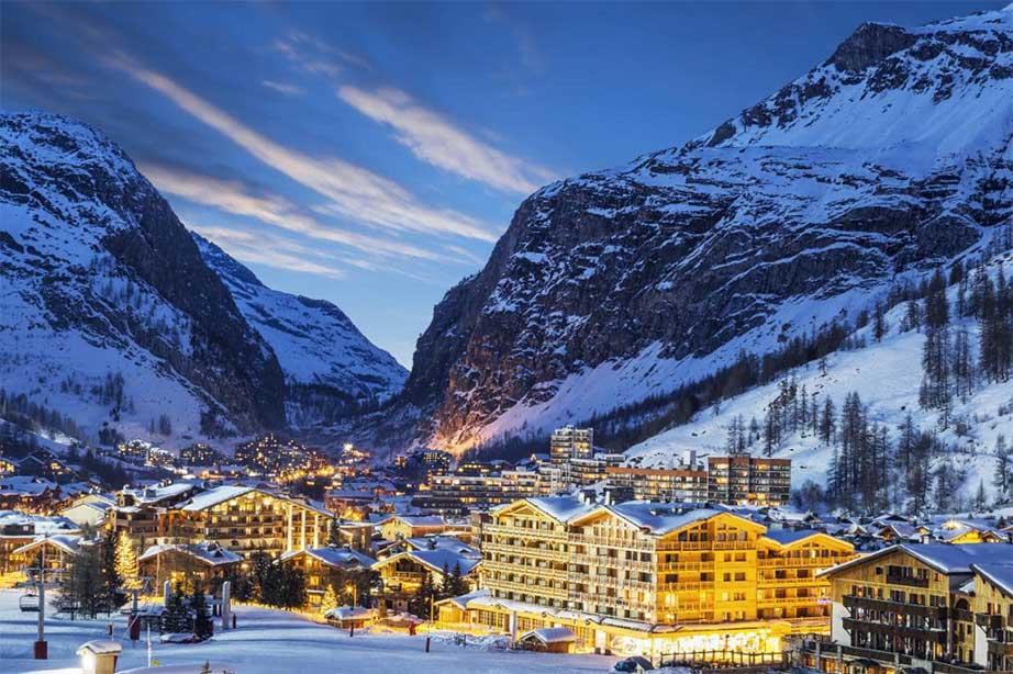 verlicht dorp in het donker met sneeuw op bergtoppen grenoble