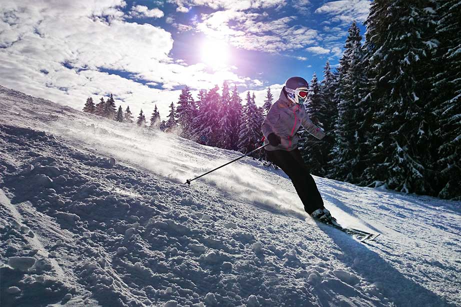 skiester gaat de berg af met sneeuw en zon