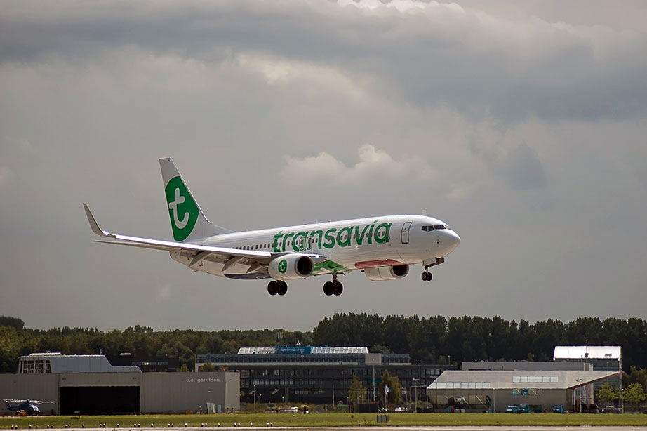 transavia vliegtuig landt bij bewolkte lucht