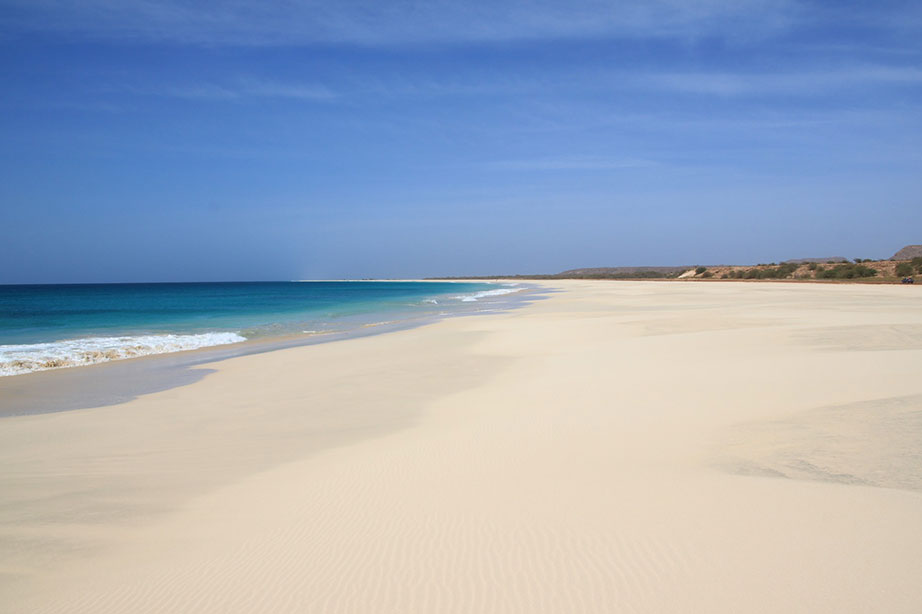 strand en zee bij blauwe lucht