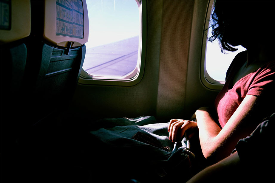 vrouw kijkt uit raam van vliegtuig