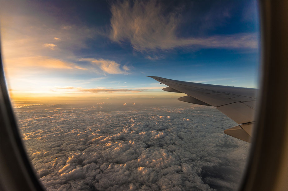 ondergaande zon boven de wolken met vliegtuigvleugel