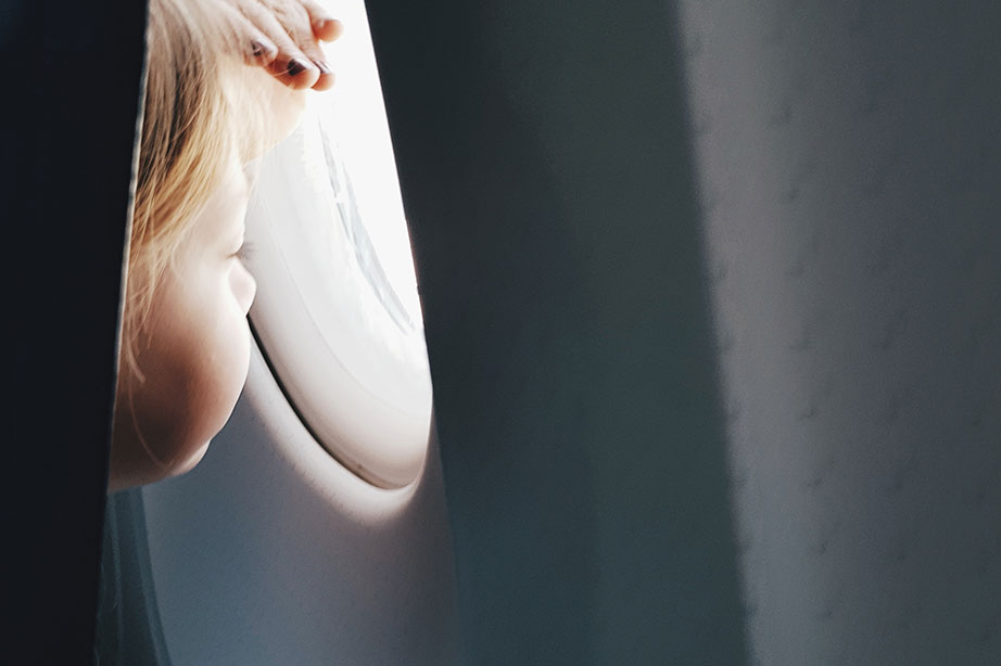klein kind kijkt uit vliegtuigraam