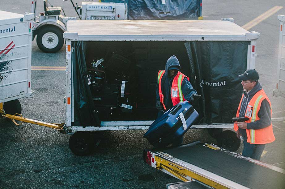 bagage afhandelaren bij vliegtuig met koffers