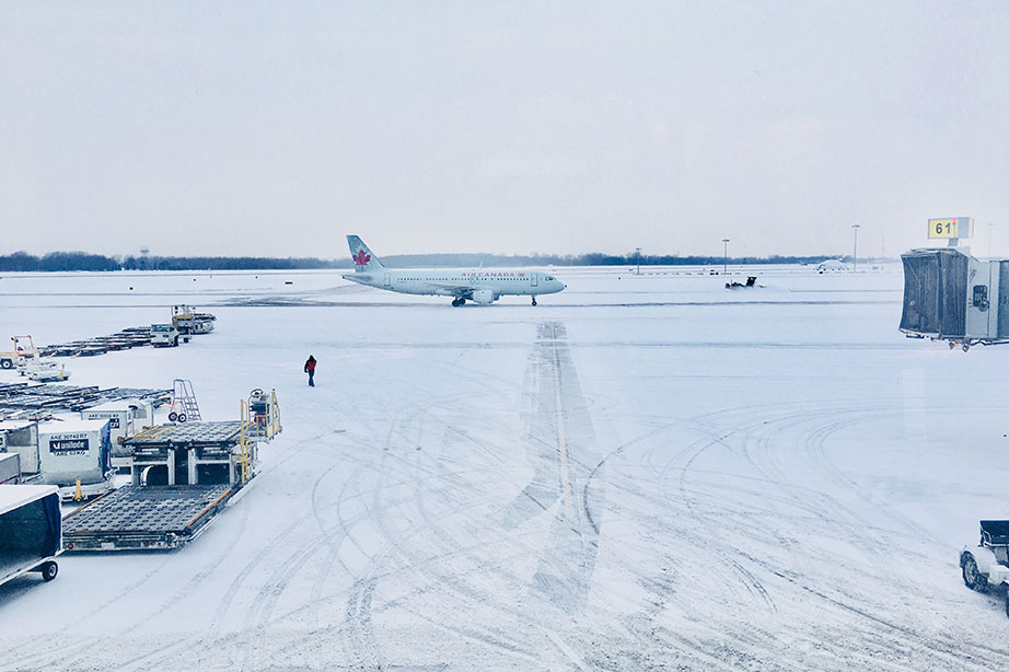 Air Canada toestel geparkeerd op vliegveld in de sneeuw