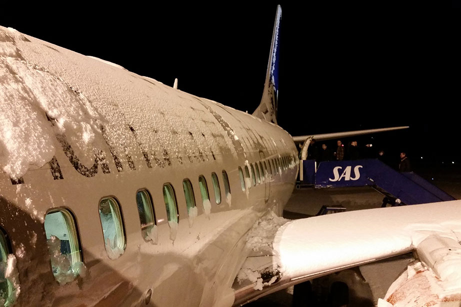 sas vliegtuig bedekt met sneeuw in het donker