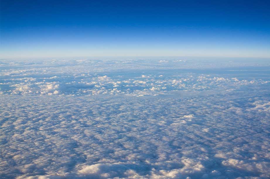 blauwe lucht boven de wolken vanuit het vliegtuig