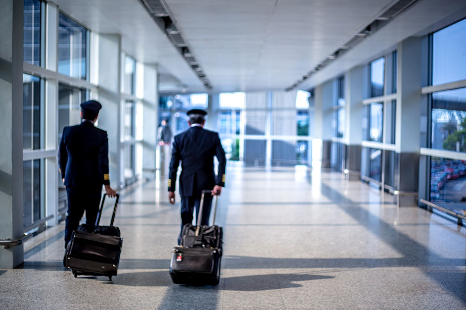 Twee piloten wandelen door de luchthaven