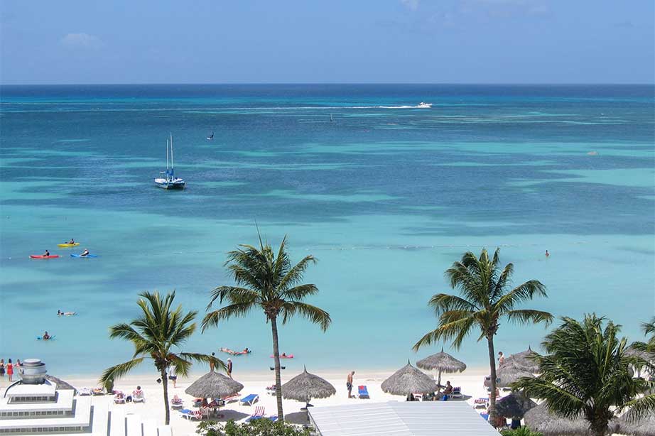 wit strand met palmbomen en zee