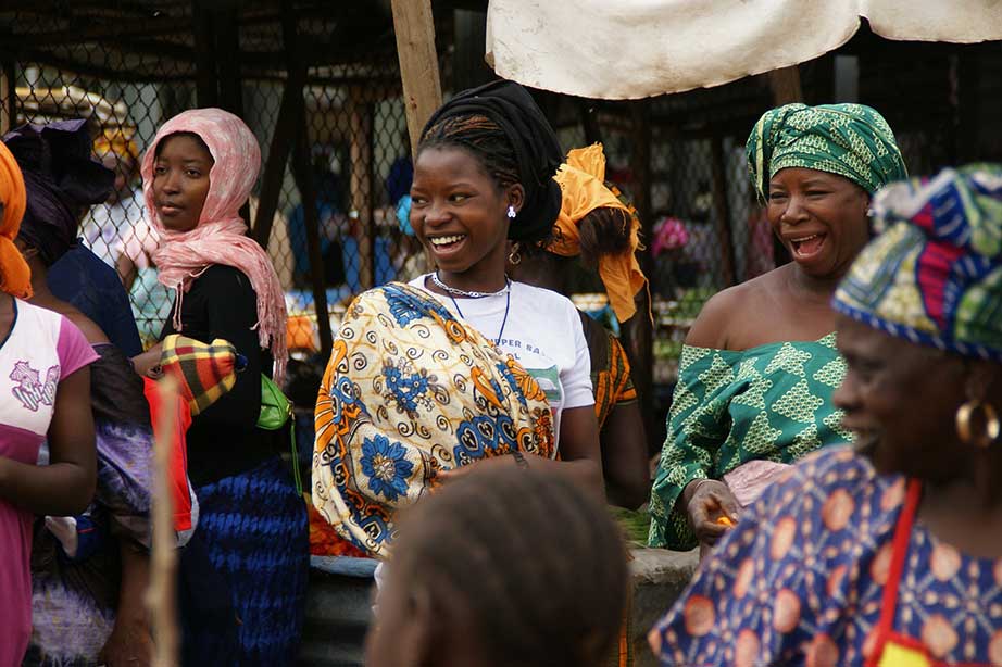 vrouwen lachen op markt in gambia