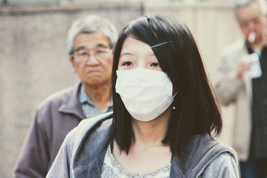 vrouw met mondkapje ter bescherming voor coronavirus