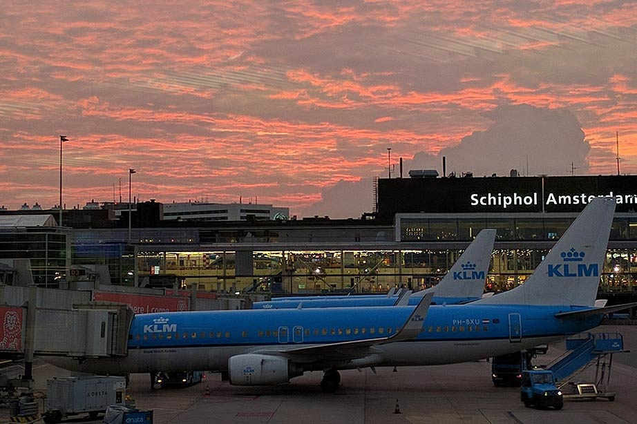 Zicht op terminal Schiphol Airport met ondergaande zon