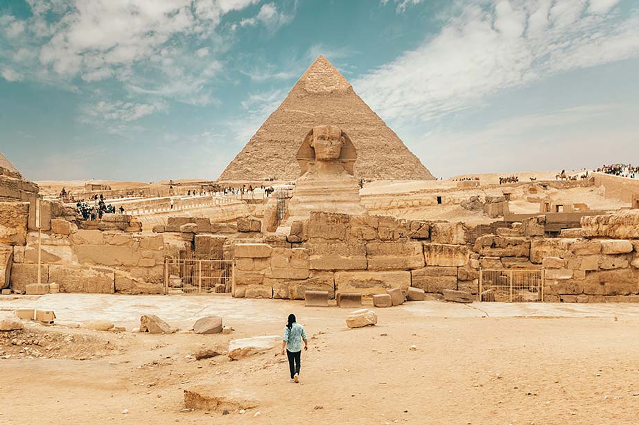 Toerist wandelt voor een piramide in de stad Luxor in Egyote
