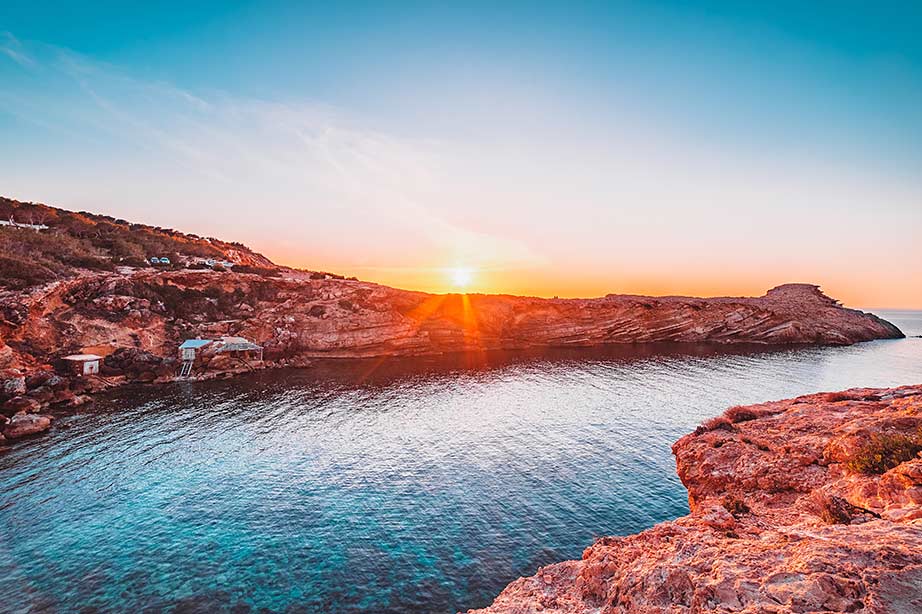 Uitzicht op een strand met ondergaande zon op Ibiza