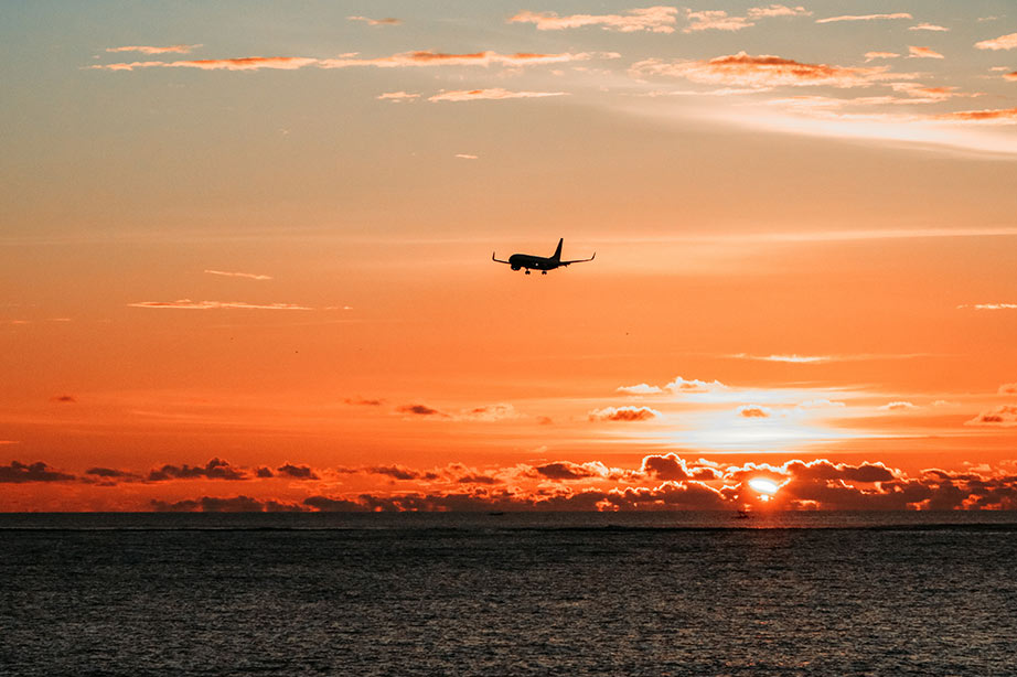 Vliegtuig in de lucht met een ondergaande zon