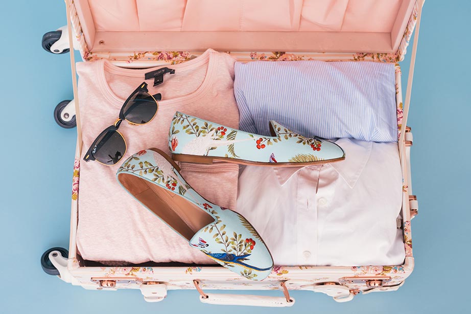 Roze koffer met kleding en schoenen