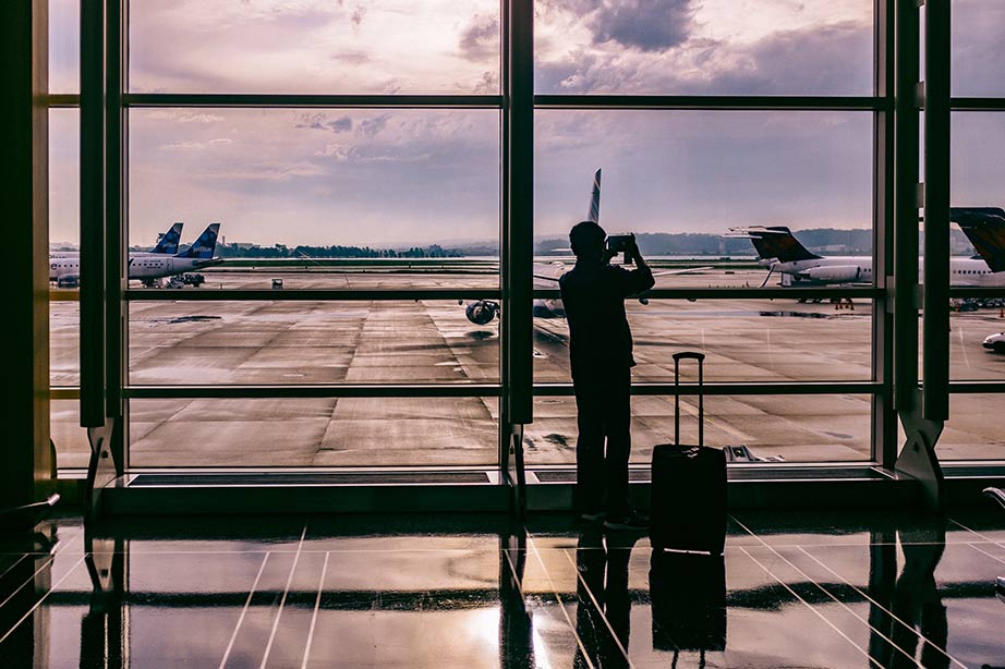 Man fotografeert met zijn mobiel op luchthaven