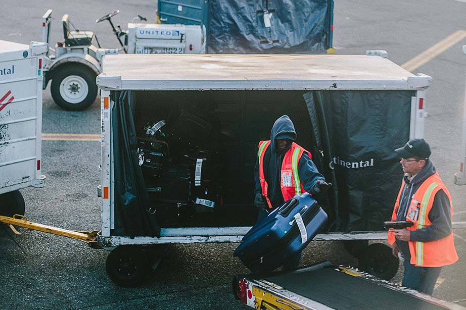 Mannen tillen koffers op een band