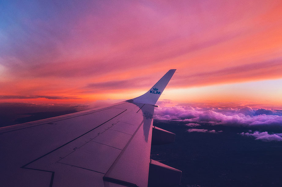 vleugel klm vliegtuig in roze rode lucht
