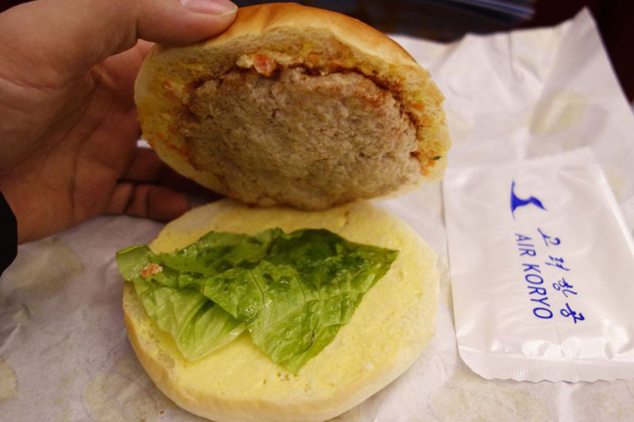 Vliegtuigeten: een broodje met boter en een plakje sla en een kleine hamburger