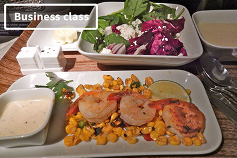Vliegtuig eten businessclass met garnalen en een salade