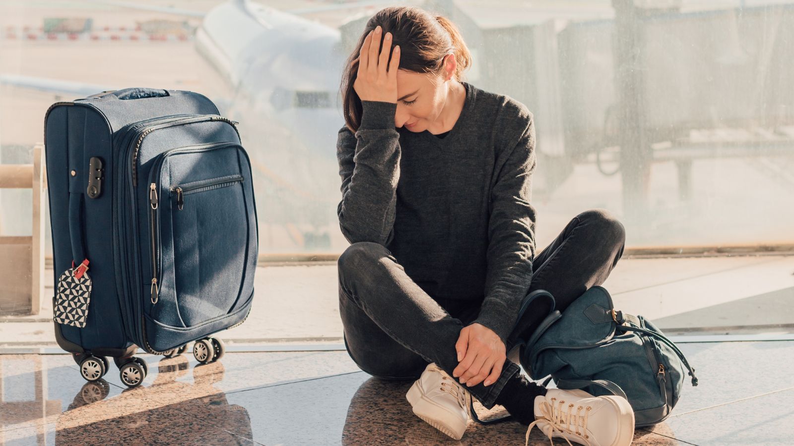 Een vrouw die zichtbaar baalt dat de vlucht vertraagd is