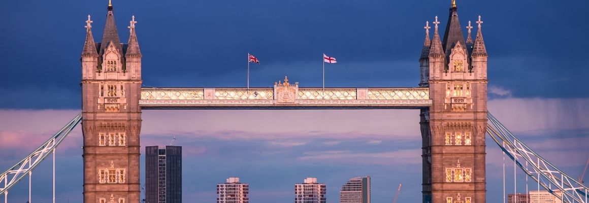 Tower Bridge in Londen bij schemering, met verlichte torens en een donkere avondlucht.