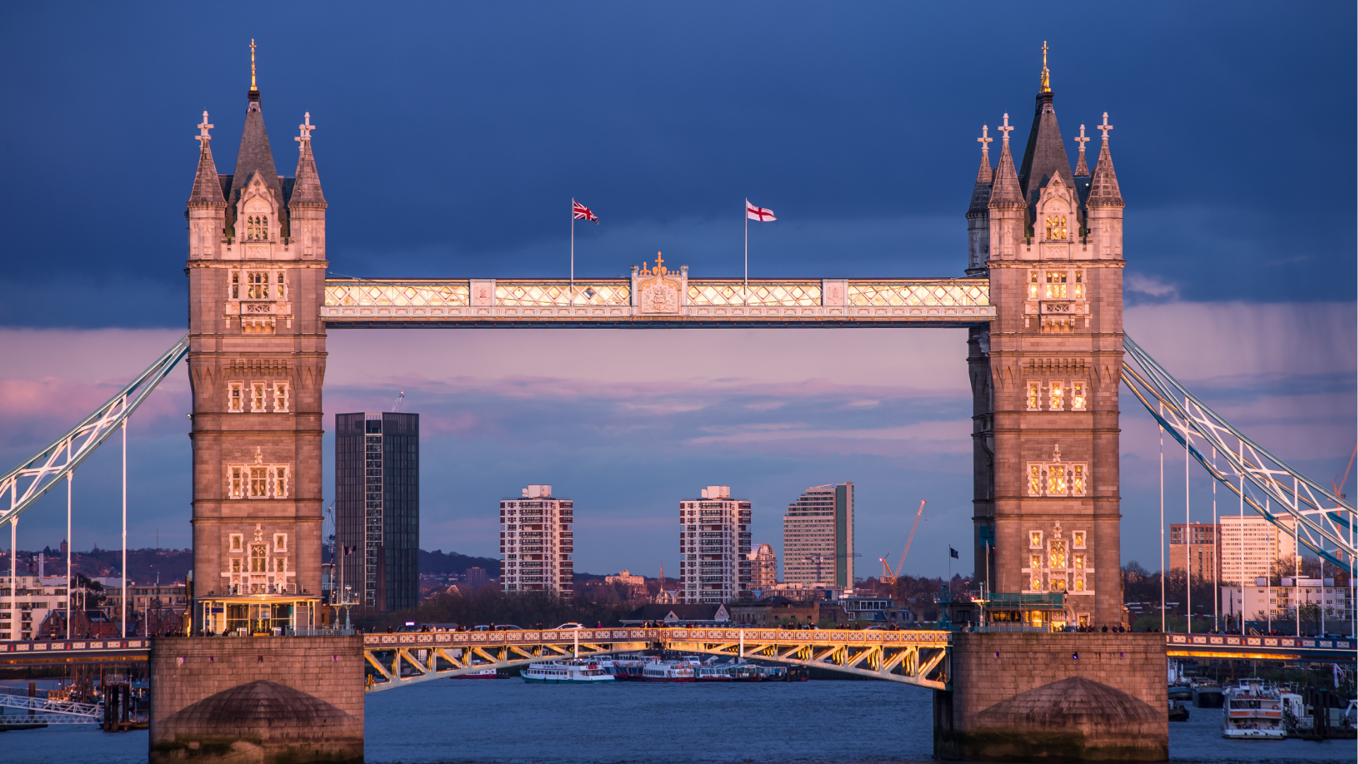 Tower Bridge in Londen bij schemering, met verlichte torens en een donkere avondlucht.