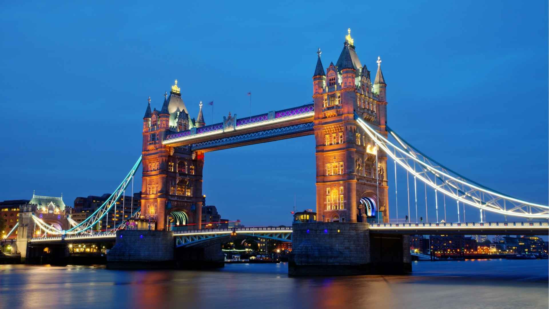 Tower Bridge in Londen bij schemering, met verlichte torens en een donkere avondlucht.
